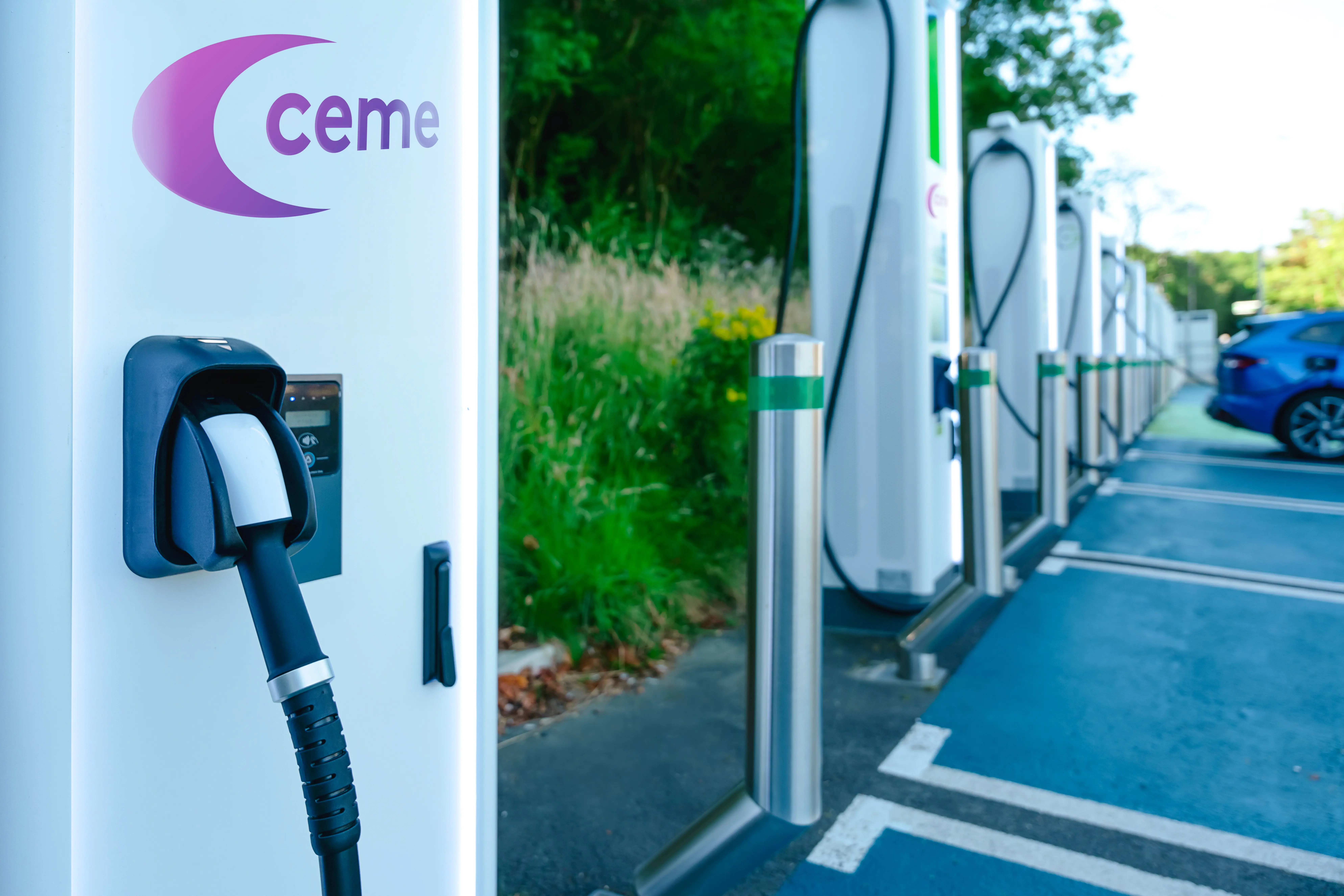A row of new white EV charging stations in an outdoor carpark.