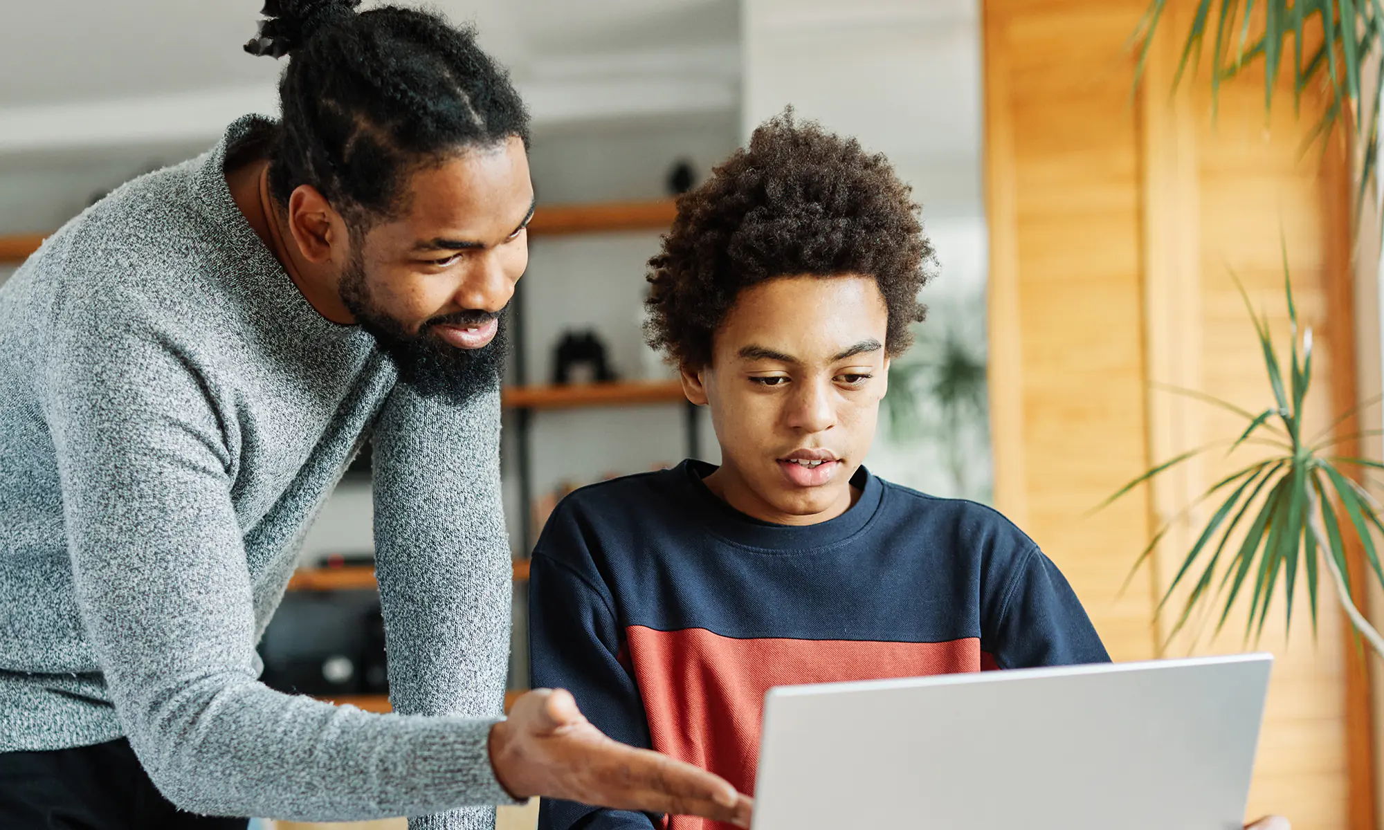 A father talks his son through his idea on their family laptop.